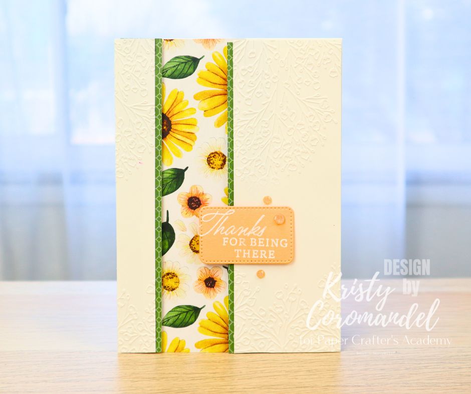 Card with sunflower patterned paper and embossed background – layering tip example