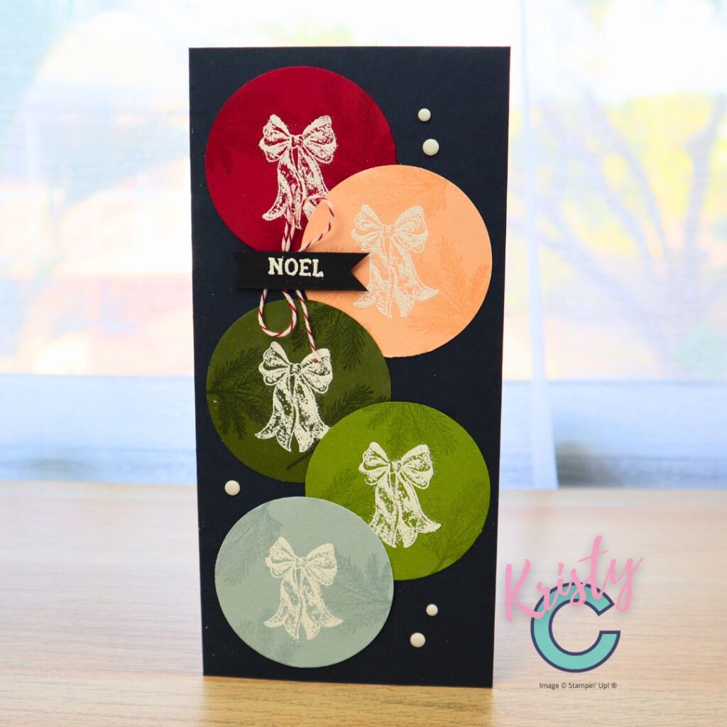 Handmade Christmas card featuring heat-embossed white bows on colourful circle ornaments with “NOEL” sentiment, created using Stampin’ Up! Magic & Hope stamp set.