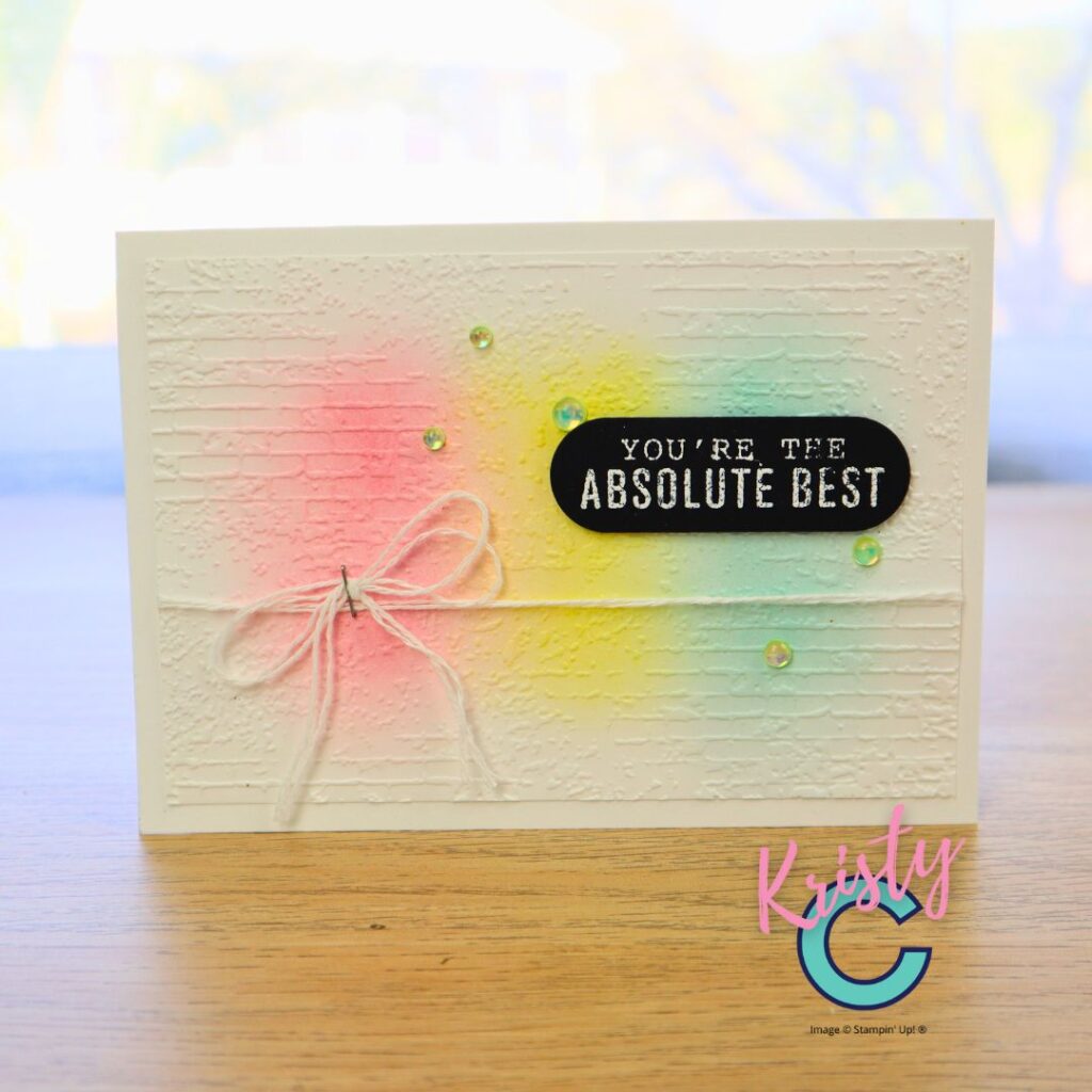 Handmade greeting card featuring embossed brick background and pastel ink-blended colours in pink, yellow, and aqua, finished with black embossed sentiment