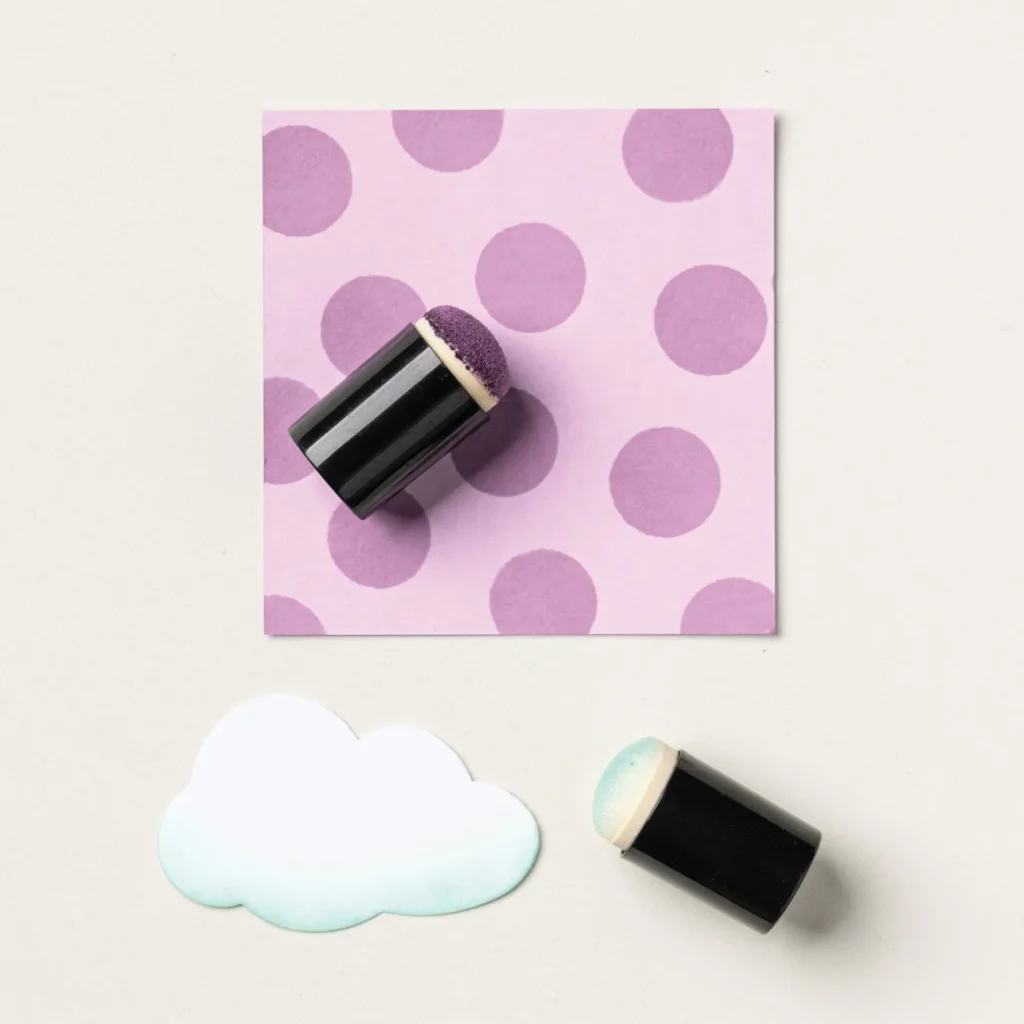 Close-up of sponge daubers blending purple ink dots and soft blue edges on cardstock for beginner paper crafting.