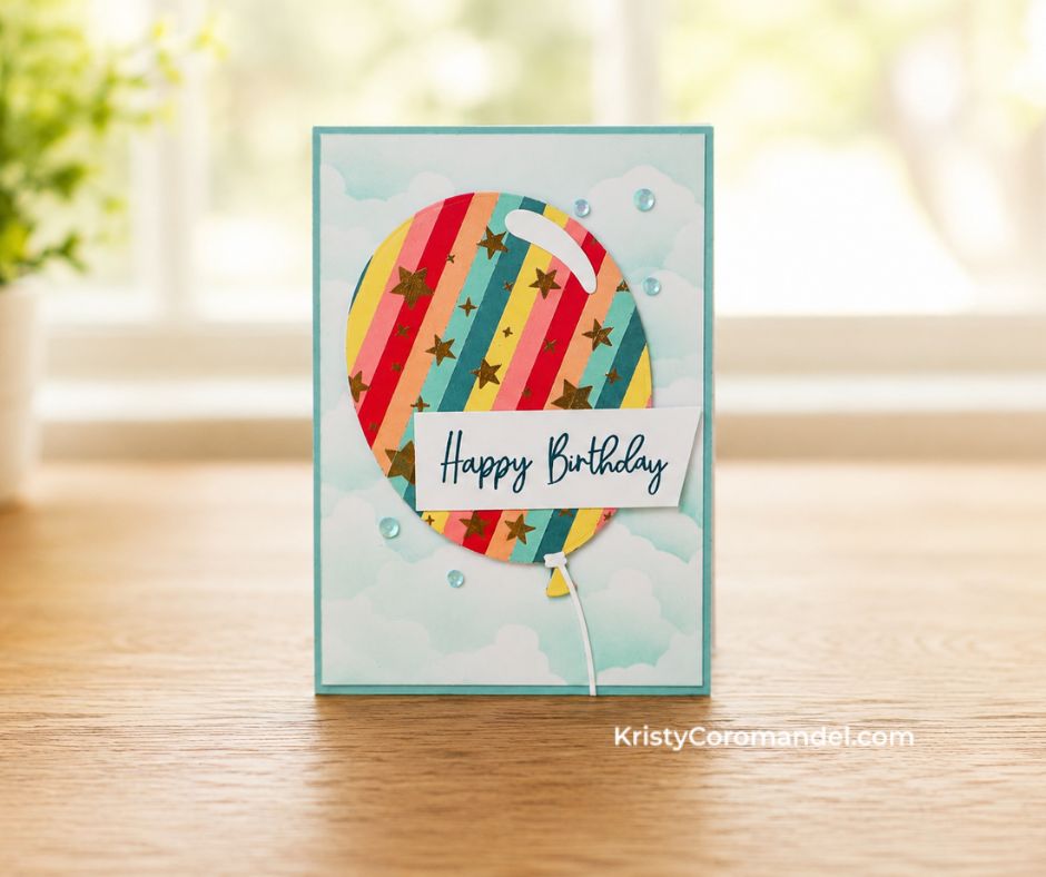 Soft teal birthday card with a striped gold star balloon on a sponged cloud background, "Happy Birthday" sentiment