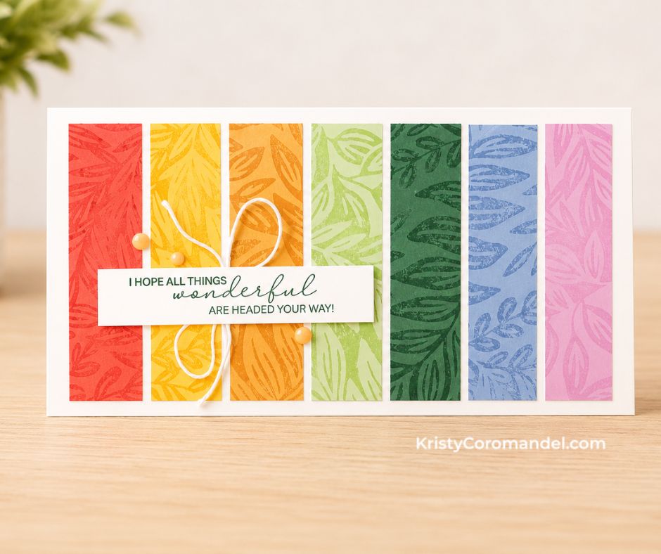 Handmade slimline-style greeting card featuring the Moody Leaves Background Stamp stamped in rainbow colours and cut into vertical strips with a layered sentiment and white twine on a white card base.