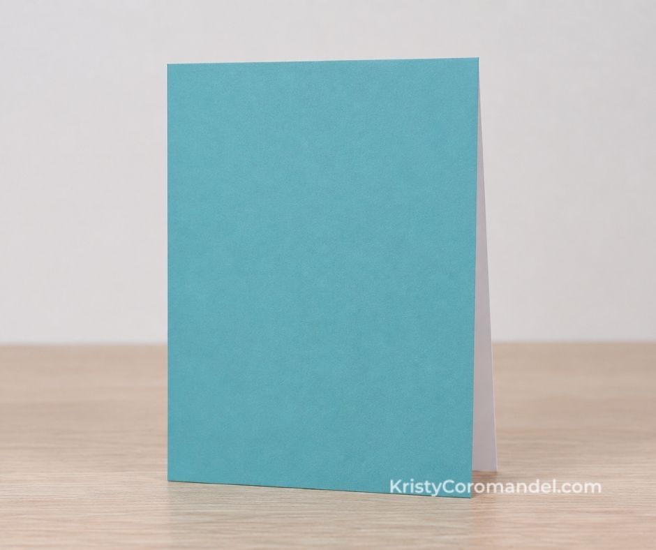 Thick Basic White card base standing upright with a teal cardstock layer added to the front to create the look of a coloured card.