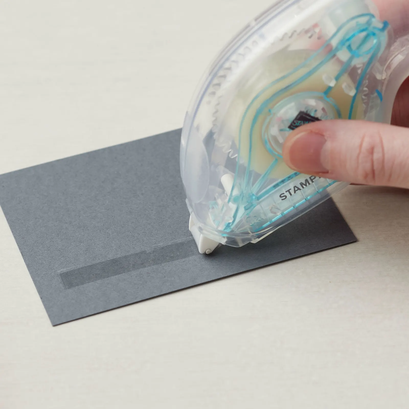 Applying Stampin’ Seal tape runner adhesive to the back of cardstock for cardmaking